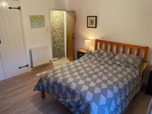 a bedroom with a bed with a checkered comforter at Beautiful home perfect for families&professionals in Nantwich