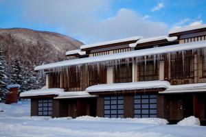 un edificio cubierto de nieve en Kasara Niseko Village Townhouse - Small Luxury Hotels of The World, en Niseko