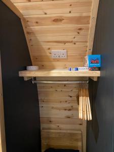 una parete in legno con mensola e interruttore luminoso di Craigend Farm Holiday Pods - The Curly Coo a Dumfries