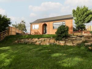 a brick house on a hill with a stone wall at Foulsyke Farm Bungalow in Saltburn-by-the-Sea
