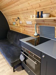 a tiny house with a black desk and a couch at Craigend Farm Holiday Pods - The Curly Coo in Dumfries