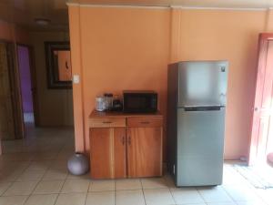 a kitchen with a refrigerator and a microwave at villa tavago in Cahuita