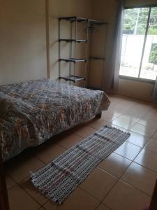 a bedroom with a bed and two rugs on the floor at villa tavago in Cahuita