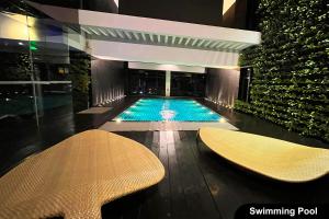 a swimming pool in a building with two tables and chairs at the Gramercy Residences NEW RELEASE in Manila