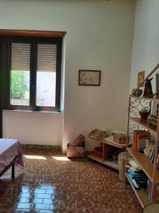 a room with a window and a brick floor at Sweet Home in Oliena