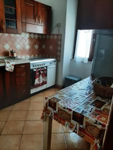 a kitchen with a stove and a table in it at Sweet Home in Oliena