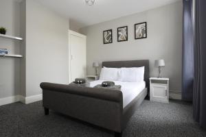 1 dormitorio con cama y sofá en Fully Refurbed : DRIVEWAY : HotTub : Central Location en Portsmouth