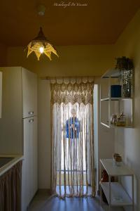 a kitchen with a window with a curtain at Casa Vacanza Le Dune- Sole in Maruggio