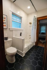 a bathroom with a toilet and a tub and a sink at Gulf Coast Craftsman - Cozy, Charming & Central! in Gulfport