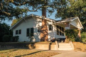 a white house with a chimney and a tree at Gulf Coast Craftsman - Cozy, Charming & Central! in Gulfport