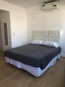 1 dormitorio con 1 cama grande y cabecero blanco en Espectacular Departamento en San Telmo - Piscina, Lavadero y Parrilla en Buenos Aires