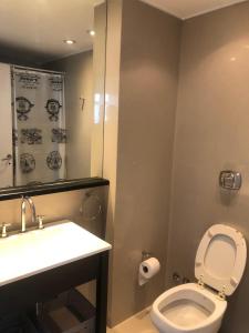 a bathroom with a white toilet and a sink at Espectacular Departamento en San Telmo - Piscina, Lavadero y Parrilla in Buenos Aires