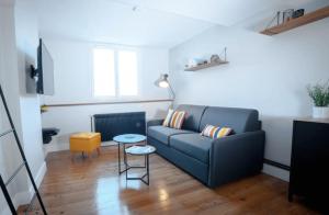 a living room with a couch and a table at Coup de Cœur assuré pour ce T2 rénové Hyper centre in Biarritz