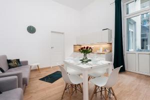 Szpitalna Premium Apartment في كراكوف: غرفة معيشة مع طاولة وكراسي بيضاء