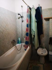 a bathroom with a tub and a toilet and a sink at Pinnettu sardo casa di campagna in ecosistema insetti e animaletti simpatici in condivisione,Leggere attentamente Prima di prenotare in Oliena