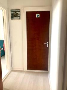 een bruine deur in een kamer met een houten vloer bij City Studio in Swansea