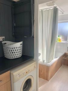een wasruimte met een wasmachine en een bad bij City Studio in Swansea