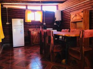 a kitchen with a table and a refrigerator at Cabañas Achalay in Valle Hermoso