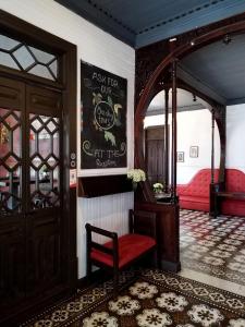 a room with a red chair and a sign on the wall at Casa Aldea in San José