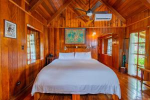 sypialnia z dużym łóżkiem w drewnianym pokoju w obiekcie Palau Carolines Resort w mieście Koror