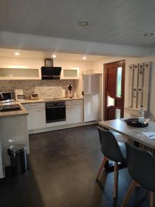 a kitchen with white appliances and a table with chairs at Zum Buchenblick in Sankt Wendel