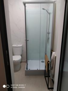 a bathroom with a toilet and a glass shower at Wood Steel & Glass in Marinha Grande