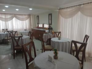 a dining room with tables and chairs and a piano at Novo Grande Hotel in Ribeirão Preto