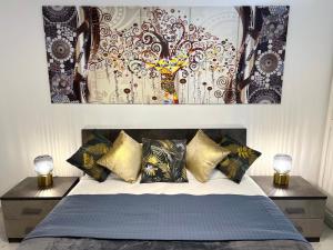 a bedroom with a bed with pillows and paintings on the wall at FELLINI SUITES Lungomare near the sea in Catania