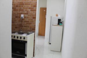 eine Küche mit einem Herd und einem Kühlschrank in der Unterkunft apartamento fruto da terra 302 VISTA LATERAL MONTANHAS in Caparaó Velho