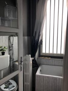 een badkamer met een bad, een toilet en een raam bij Appartamento Farfalla Sara pala inalpi in Turijn