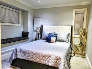 um quarto com uma cama com almofadas azuis e uma janela em New Urban Modern Main St. Coach House em Vancouver