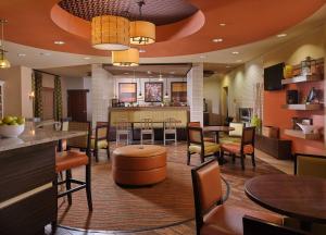 a restaurant with tables and chairs and a bar at Best Western Plus Tupelo Inn & Suites in Tupelo