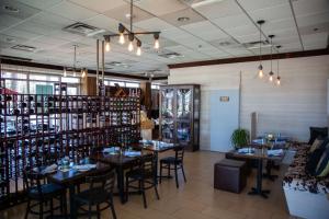 uma sala de jantar com mesas e cadeiras e prateleiras de vinho em Best Western Plus North Miami-Bal Harbour em North Miami