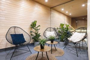 three chairs with pillows and plants in a room at Best Western Princess Hotel in Norrköping