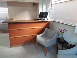 a office with a desk and a chair and a computer at Novo Grande Hotel in Ribeirão Preto