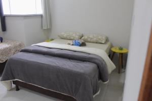 Schlafzimmer mit einem Bett, einem Tisch und einem Fenster in der Unterkunft apartamento fruto da terra 302 VISTA LATERAL MONTANHAS in Caparaó Velho