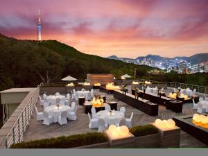 un restaurante con mesas blancas y sillas en la azotea en Banyan Tree Club & Spa Seoul, en Seúl