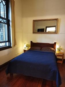 a bedroom with a blue bed and a mirror at Casa Aldea in San José