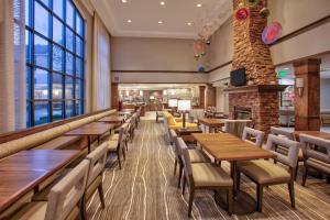 a restaurant with tables and chairs and a fireplace at Staybridge Suites Corning, an IHG Hotel in Corning