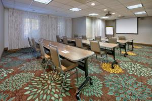 a conference room with tables and chairs and a screen at Staybridge Suites Corning, an IHG Hotel in Corning