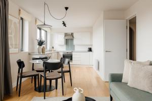 a kitchen and living room with a table and chairs at Sonder The Bard in London
