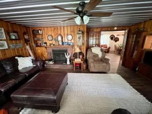 uma sala de estar com um sofá e uma ventoinha de tecto em Quiet Farmhouse close to major theme parks em Ridge Manor