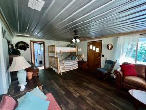 een woonkamer met een bank en een bed bij Quiet Farmhouse close to major theme parks in Ridge Manor