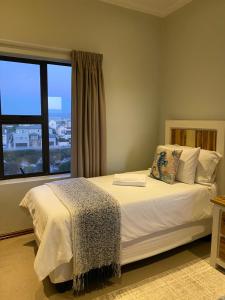 a bedroom with a bed with a large window at Waves Edge CP3 in Cape Town