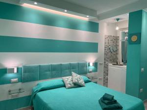 een slaapkamer met een groen bed en een gestreepte muur bij IL TURCHESE in Cagliari