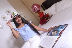 Una donna giace su un letto con un libro di Hotel Santa Juana a Santa Rosa de Cabal
