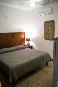a bedroom with a bed with a wooden headboard at DownTown Rooms San Pancho in San Francisco