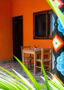 una mesa y sillas en una habitación con una pared de color naranja en DownTown Rooms San Pancho en San Francisco