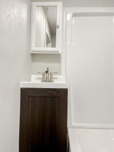 a bathroom with a sink and a mirror at Sleepover Historic Downtown Springfield Apartments in Springfield