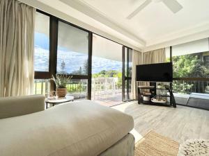 a bedroom with a bed and a large window at Surf Haven opposite Clarkes Beach pool walk to CBD in Byron Bay
